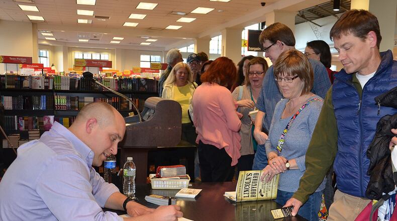 Air Force Research Laboratory Materials and Manufacturing Directorate engineer and author TJ Turner signs copies of his first novel, “Lincoln’s Bodyguard,” in April 2015. (U.S. Air Force photo/Lori Hughes)
