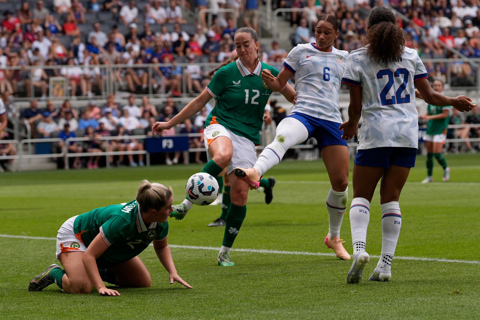United States forward Lynn Biyendolo (6) kicks the ball past Ireland defenders Jessie Stapleton (2) and Anna Patten (12) as United States forward Yazmeen Ryan (22) moves in during the first half of an international friendly women's soccer match in Cincinnati, Sunday, June 29, 2025. (AP Photo/Carolyn Kaster)
