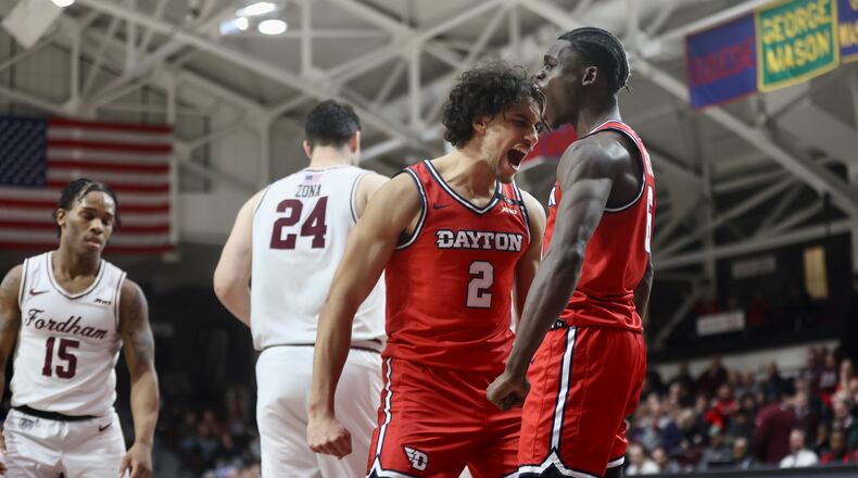 Dayton's Nate Santos, center, reacts after a basket by Enoch Cheeks, right, in the second half against Fordham on Wednesday, Feb. 12, 2025, at Rose Hill Gym in Bronx, N.Y. David Jablonski/Staff