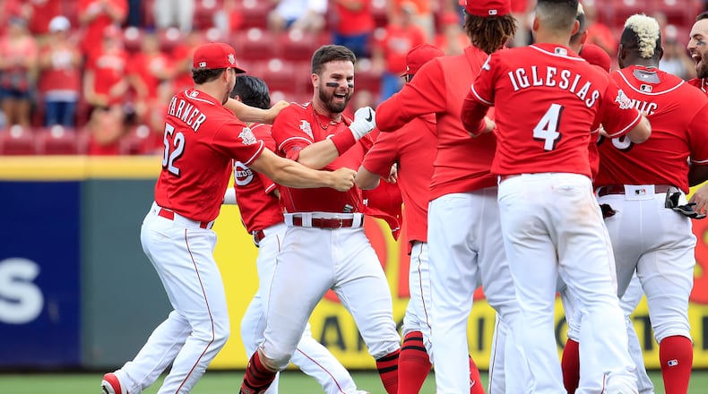 CINCINNATI, OHIO - JUNE 19: Jesse Winker #33 (third from left facing camera) of the Cincinnati Reds celebrates with teammates after hitting a game winning RBI single in the 9th inning against the Houston Astros at Great American Ball Park on June 19, 2019 in Cincinnati, Ohio. (Photo by Andy Lyons/Getty Images)