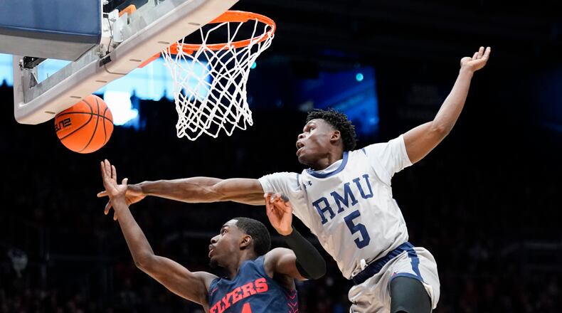 Robert Morris guard Enoch Cheeks (5) blocks a shot attempt from Dayton guard Kobe Elvis (24) during the first half of an NCAA college basketball game, Saturday, Nov. 19, 2022, in Dayton, Ohio. (AP Photo/Joshua A. Bickel)