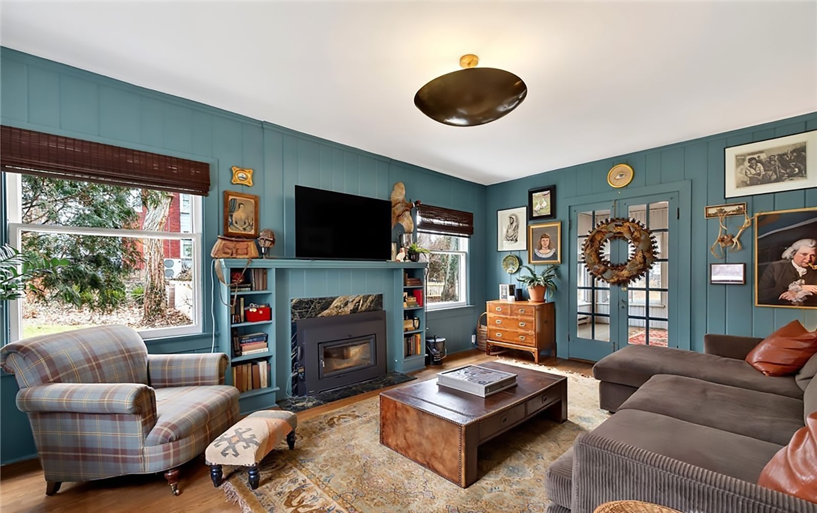 The family room has painted wood paneling on the walls, hardwood floors and a woodburning fireplace with new stove insert capable of heating the entire first floor. CONTRIBUTED