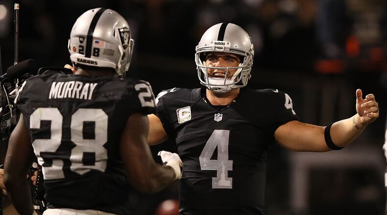 OAKLAND, CA - NOVEMBER 06: Derek Carr #4 of the Oakland Raiders and Latavius Murray #28 celebrate after a touchdown during the fourth quarter against the Denver Broncos at Oakland-Alameda County Coliseum on November 6, 2016 in Oakland, California. (Photo by Ezra Shaw/Getty Images)