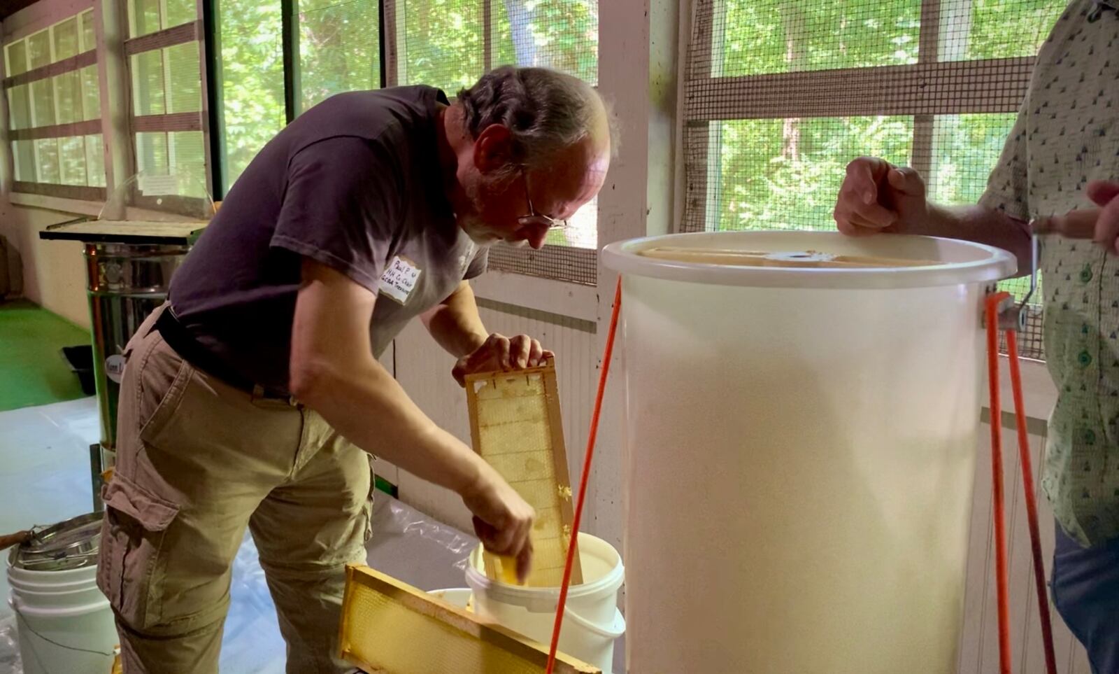 Paul Piszkiewicz of the Greene County Beekeepers Association demonstrates how to extract honey for visitors to the Honey Harvest festival Saturday. LONDON BISHOP/STAFF
