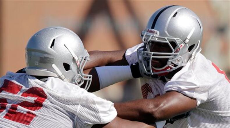 FILE - In this Aug. 6, 2012, file photo, Ohio State's Johnathan Hankins, left, and Adolphus Washington compete during NCAA college football practice in Columbus, Ohio. Ohio State concludes its 15 spring practices with an intrasquad scrimmage on Saturday, April 13, 2013, when the Buckeyes bus to Cincinnati to play at Paul Brown Stadium. The team has been split into two squads by coach Urban Meyer and his staff with quarterbacks Braxton Miller and Kenny Guiton off limits for contact. (AP Photo/Jay LaPrete, File)