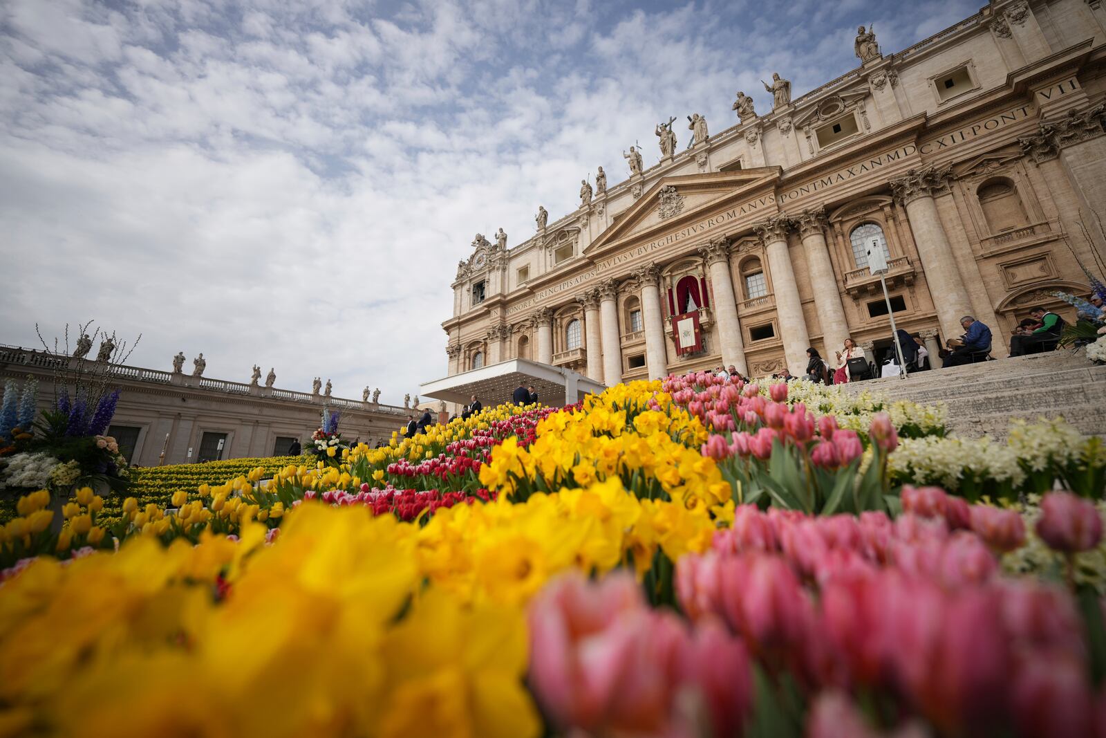 Flowers are set up for the Easter mass in St. Peter's Square at the Vatican Sunday, April 20, 2025. (AP Photo/Andrew Medichini)