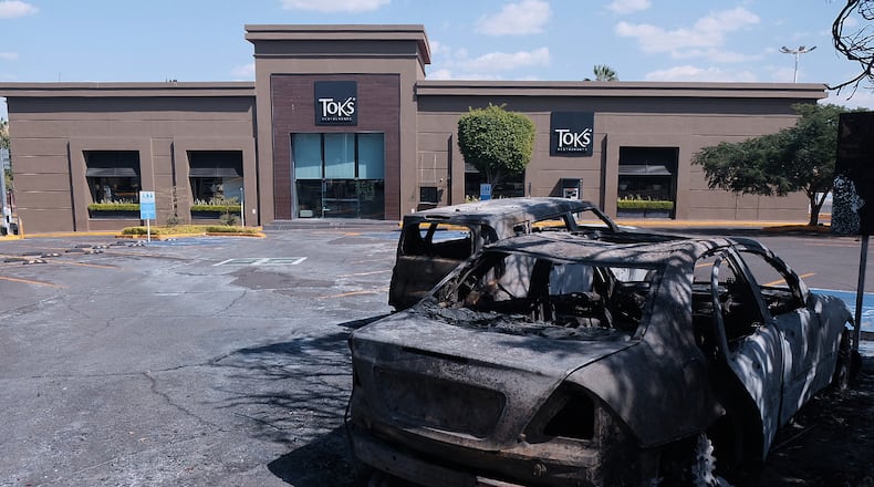 Charred vehicles sit in a parking lot sit outside a shopping mall in Guadalajara, Jalisco state, Mexico, Sunday, Feb. 22, 2026, as authorities reported that the Mexican Army killed Jalisco New Generation Cartel leader Nemesio Oseguera, known as "El Mencho." (AP Photo/Alejandra Leyva)