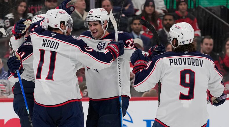 Columbus Blue Jackets' Sean Monahan, center, celebrates his goal with teammates during the third period of an NHL hockey game against the New Jersey Devils in Newark, N.J., Monday, Dec. 1, 2025. (AP Photo/Seth Wenig)