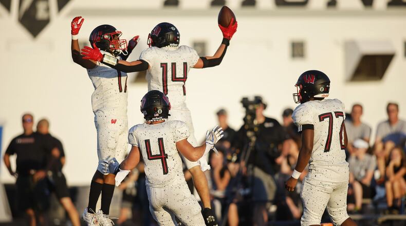 Lakota West's Brennan Remy (14) celebrates his touchdown with teammates Coby Taylor (17), Trent Lloyd (4), and Tony Curtis (72) during their 49-6 win over Lakota East in their football game Friday, Aug. 26, 2022 at Lakota East High School in Liberty Township. NICK GRAHAM/STAFF