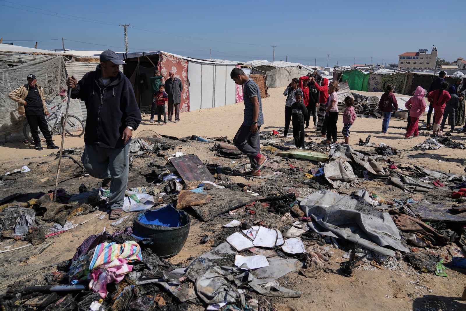 Palestinians inspect the remains of a displacement tent hit by an Israeli airstrike overnight, killing 10 members of the Abu Al-Rous family, in Khan Younis, southern Gaza Strip, Thursday, April 17, 2025. (AP Photo/Abdel Kareem Hana)