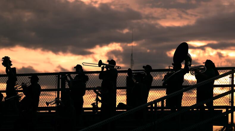 The Springfield High School Marching Band is silhouetted against the setting sun during Friday's game. BILL LACKEY/STAFF