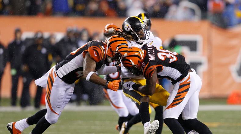 Pittsburgh Steelers’ Markus Wheaton (11) is tackled by Cincinnati Bengals’ Shawn Williams (36) and George Iloka (43) during the first half of an NFL wild-card playoff football game Saturday, Jan. 9, 2016, in Cincinnati. (AP Photo/Frank Victores)
