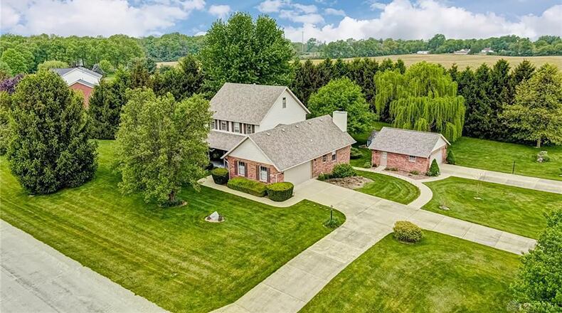 The front of the corner-lot home features a covered front porch, two garages and three driveways. Contributed photos