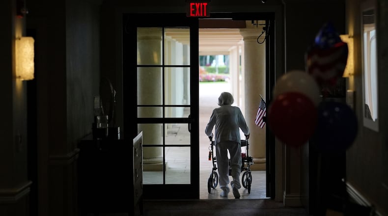 FILE - A woman uses a walker as she exits an assisted living building at the Toby and Leon Cooperman Sinai Residences, July 4, 2025, in Boca Raton, Fla. (AP Photo/Rebecca Blackwell, File)