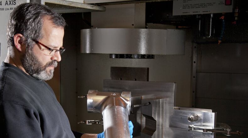 CNC machinist Maurice Bustos inspects an Army CH-47 Chinook helicopter part at Starwin Industries in Kettering. Starwin president Rick Little us very concerned about the sequestration cuts an their random nature - making business planning decisions difficult. TY GREENLEES / STAFF