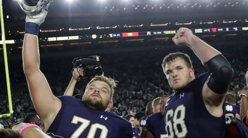 Notre Dame offensive linemen Hunter Bivin (70) and Mike McGlinchey (68) celebrate the team's 49-14 win over Southern California in an NCAA college football game, Saturday, Oct. 21, 2017, in South Bend, Ind. (AP Photo/Carlos Osorio)