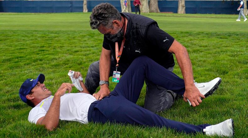 FILE - Brooks Koepka gets treated for an injury on the 12th hole during the second round of the PGA Championship golf tournament at TPC Harding Park Friday, Aug. 7, 2020, in San Francisco. Two-time champion Brooks Koepka withdrew from the U.S. Open on Wednesday, Sept. 9, because of lingering pain in his left knee that has troubled him most of the year. (AP Photo/Jeff Chiu, File)