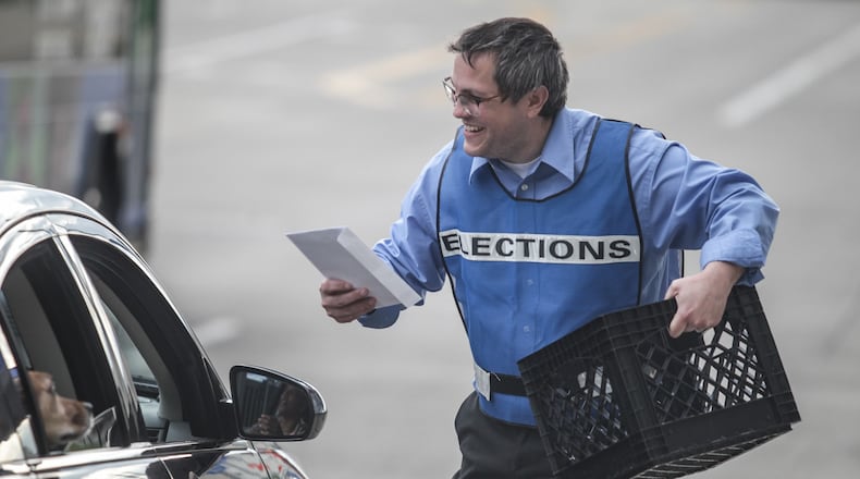 Montgomery County Board of Elections clerk Mike Miller collects ballots on Third Street in Dayton on Tuesday, April 28, 2020. JIM NOELKER / STAFF
