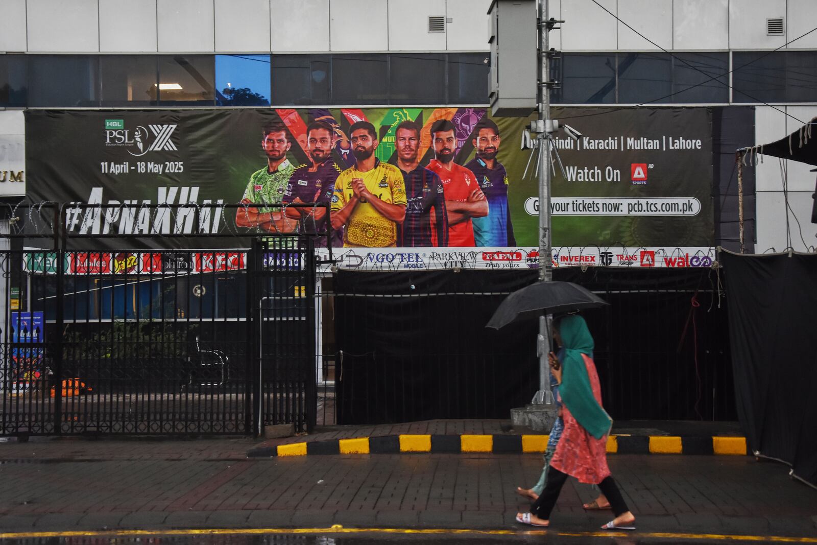 Girls walk past the Pindi Cricket Stadium, where a suspected Indian drones crashed in parking area, in Rawalpindi, Pakistan, Thursday, May 8, 2025. (AP Photo/W.K. Youszai)