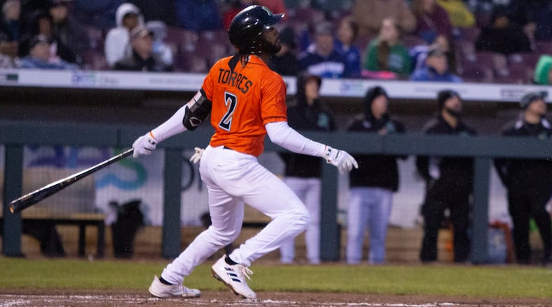 Dayton second baseman Jose Torres sends an RBI double to deep right field in the third inning of Friday night's season opener at DayAir Ballpark. Jeff Glbert/CONTRIBUTED