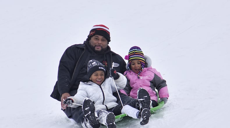 Anton Sheafe sleds down a hill with Alora Sheafe, 3, and Amir Sheafe, 4, at Voice of America MetroPark Thursday, February 18, 2021 in West Chester Twp. Many schools in the area were off for a snow day. NICK GRAHAM / STAFF