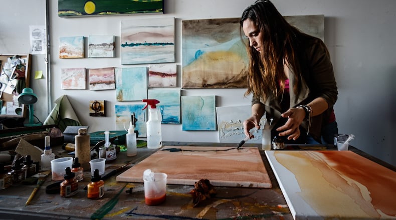 Artist Samantha Mang works on her artwork at Front Street. Mang is one of many artist who are opening their studio this small business Saturday. Mang uses acrylic paint, ink, salt and crushed walnuts to create her work. JIM NOELKER/STAFF