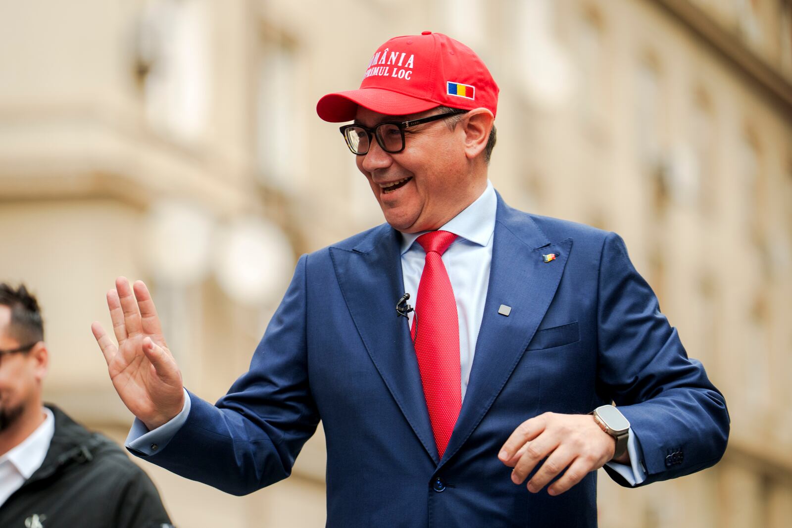 FILE - Victor Ponta, independent candidate in the upcoming presidential elections, wearing a cap that reads "Romania First" waves to supporters upon arriving to register his bid with the country's electoral authority in Bucharest, Romania, Wednesday, March 12, 2025. (AP Photo/Vadim Ghirda, File)