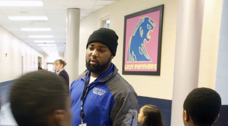 School Resource Officer Jordan Essex listens to students at Kiser PreK-6 School in Dayton. “Every day they know I’m here for them,” Essex says about the students. TY GREENLEES / STAFF