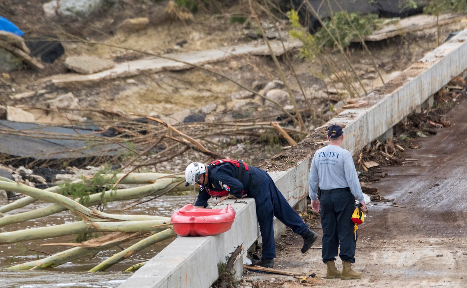 Members of the Texas A&M Task Force 1 Search & Rescue inspect the Cade Loop bridge along the Guadalupe River on Saturday, July 5, 2025, in Ingram, Texas. (AP Photo/Rodolfo Gonzalez)