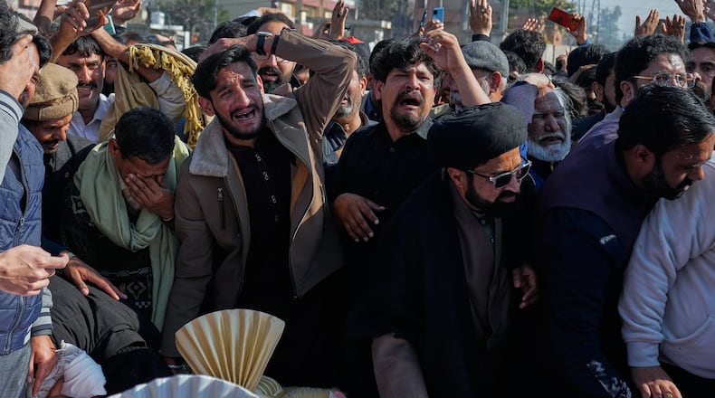 People mourn next the coffin of their relatives, who were killed in Friday's suicide bombing inside a Shiite mosque, in Islamabad, Pakistan, Saturday, Feb. 7, 2026. (AP Photo/Anjum Naveed)