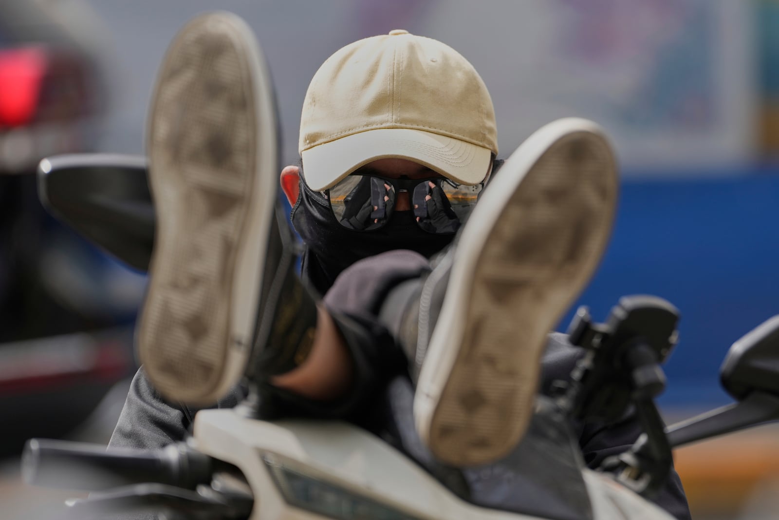 A delivery man waits on his bike at the Financial Street area in Beijing, China, Tuesday, April 8, 2025. (AP Photo/Ng Han Guan)
