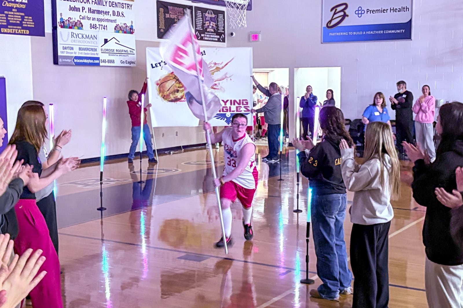 Colin Connor carries the Flying Eagles banner as he leads his team onto the court at Bellbrook Junior High on Monday, Feb. 23, 2026 for their big game against the Extinguishers. TOM ARCHDEACON / CONTRIBUTED PHOTO
