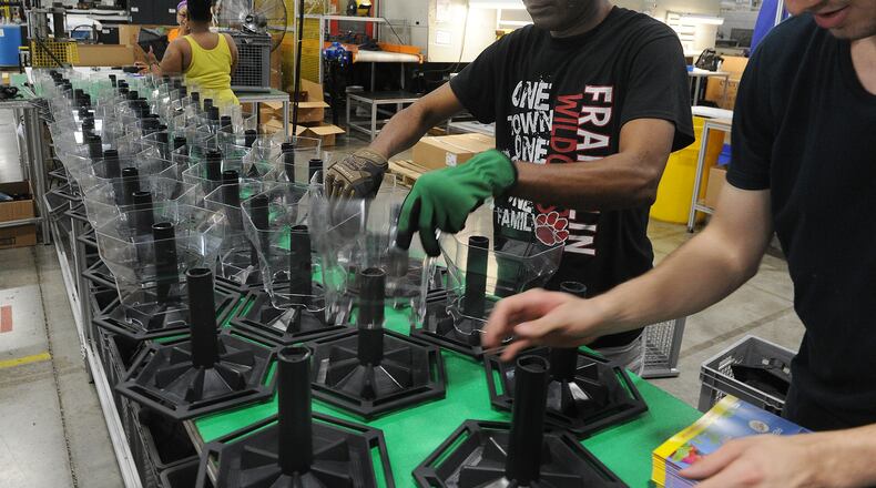Employees of Innovative Plastic Molders assemble birdfeeders. The company manufactures all the plastic parts in house. MARSHALL GORBY\STAFF