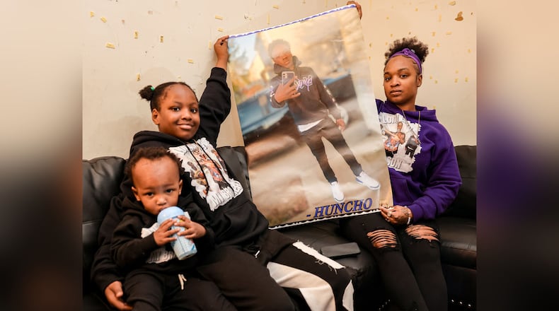 Tierra Stark (far right), her daughter Tatyana Berry (center left) and son Tayvon Berry pose with a poster of Hillary Farr Jr., who was killed outside of his West Dayton home in September. Fewer kids have been violently assaulted or killed in homicides in Dayton this year. But the tragic deaths of young people leave long-lasting scars. BRYANT BILLING/STAFF