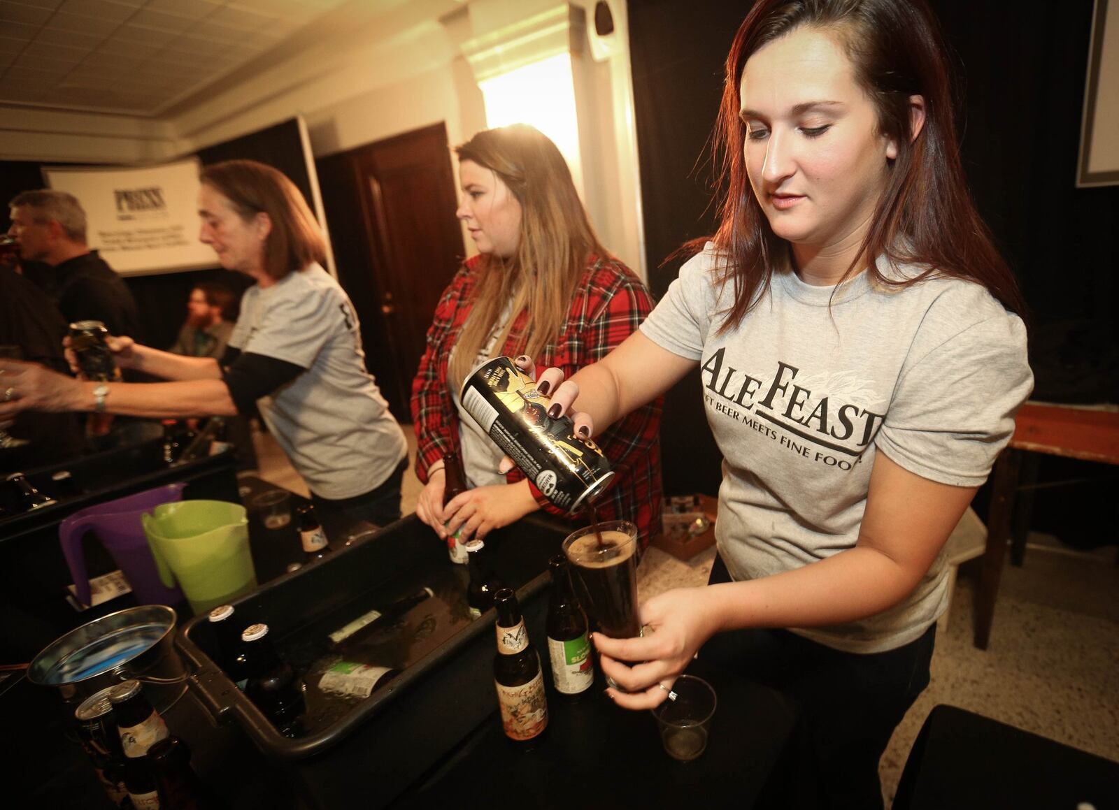 A volunteer pours at the AleFeast 2015 event. JIM WITMER / STAFF
