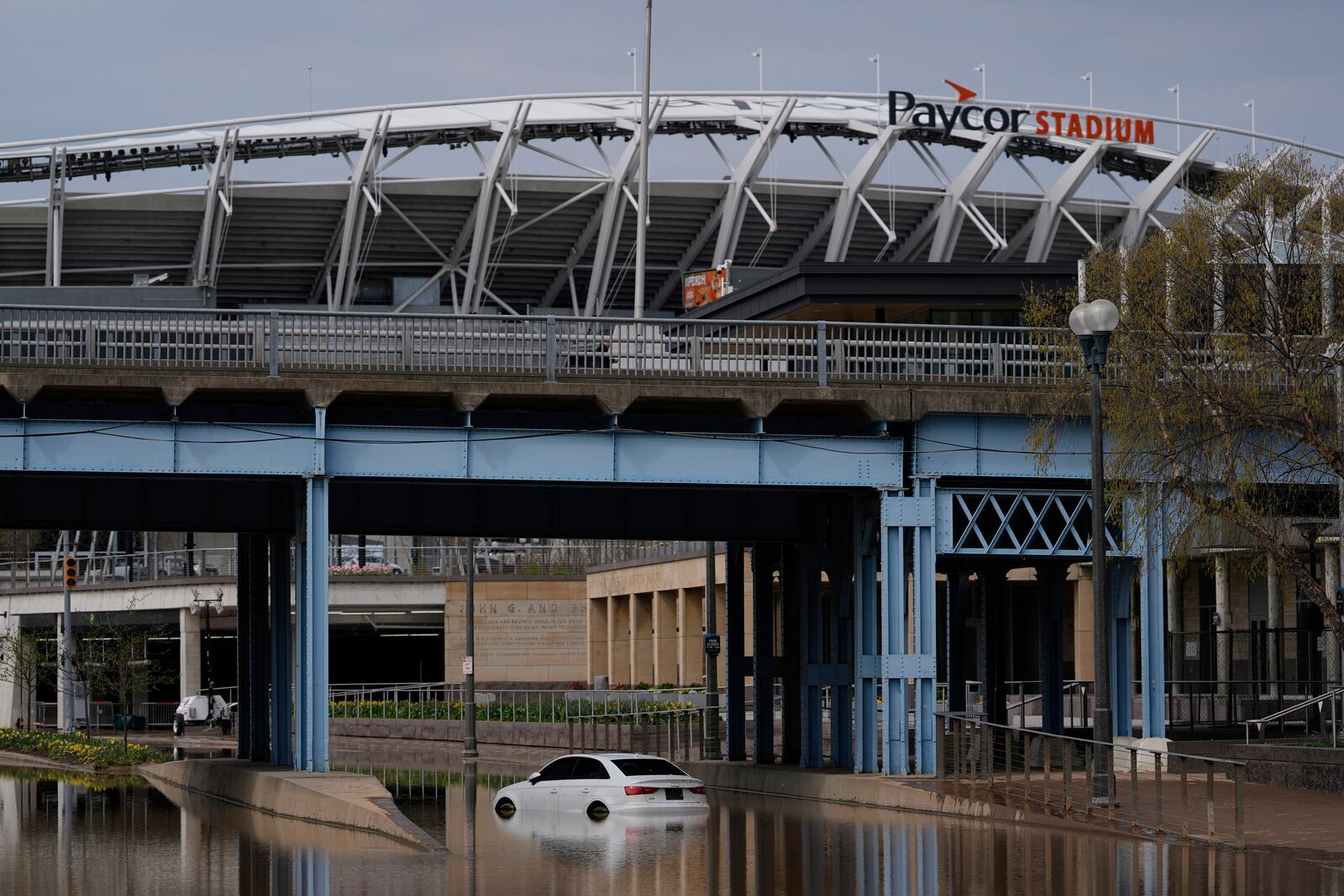 The Paycor Stadium, home of the Cincinnati Bengals NFL football team, is seen behind a Mercedes-Benz abandoned in Ohio River floodwaters at he base of the John A. Roebling Suspension Bridge, Wednesday, April 9, 2025, in Cincinnati. (AP Photo/Carolyn Kaster)