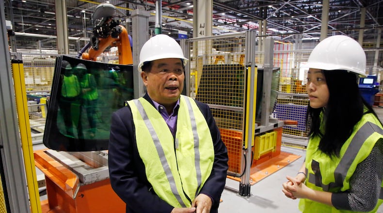 Cho Tak Wong, chairman, Fuyao Glass Industry Group Co. LTD., left, on a visit to Fuyao Glass America in Moraine. TY GREENLEES / STAFF