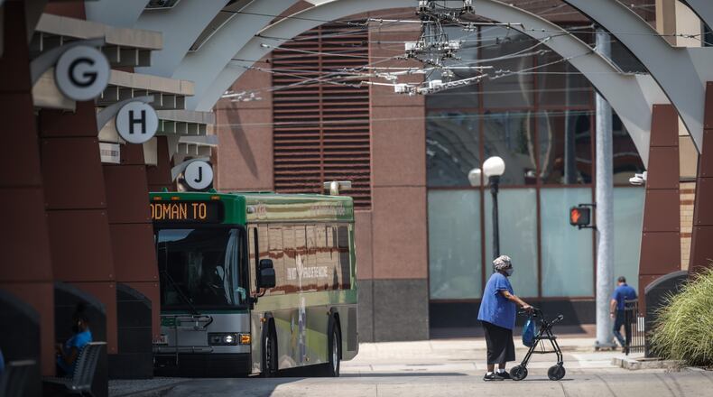 RTA riders depart and load onto buses at the RTA Hub on Main St. in Dayton Tuesday July 27, 2021. RTA is moving to a cashless system in November. About one in five riders use cash. A survey shows nearly half of the riders earn $15k or less and 92% don't have access to a vehicle. JIM NOELKER/STAFF
