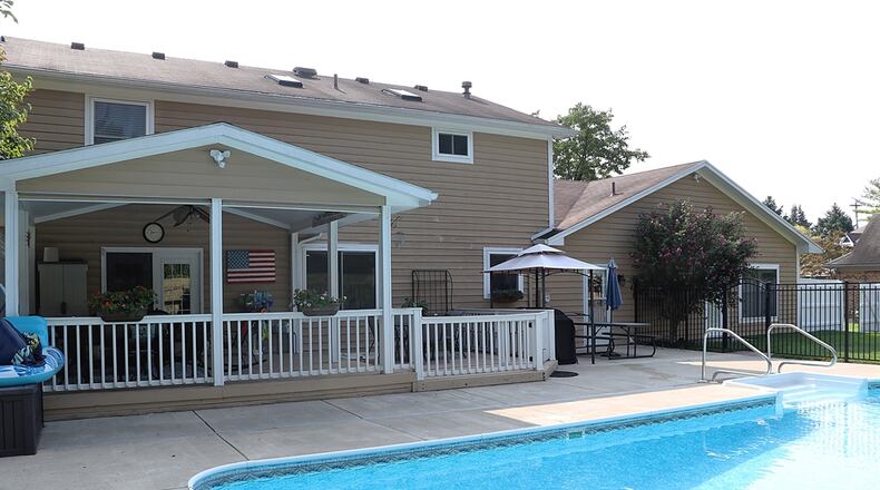 A home for sale at 4141 Abbeygate Drive has a covered outdoor seating area and a swimming pool. CONTRIBUTED