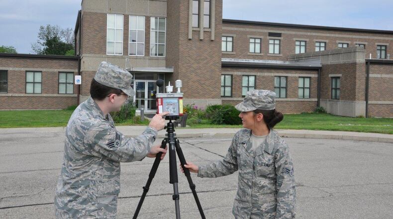 Senior Airman Alex Shuttleworth, Bioenvironmental Engineering journeyman, and Airman 1st Class Taylor Osborne, Bioenvironmental Engineering apprentice, are reading data from the Wet Bulb Globe Temperature measuring instrument July 14 near Bldg. 675, Area B, Wright-Patterson Air Force Base. (U.S. Air Force photo/W. Eugene Barnett Jr.)