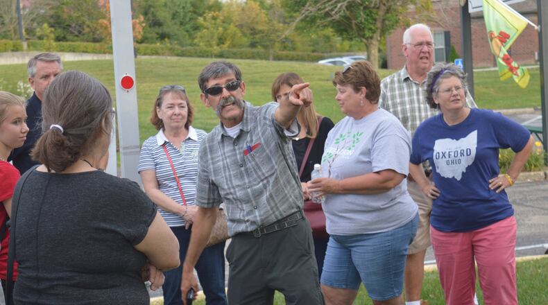 Mark Fenton points to the intersection of South Locust and West Spring streets during his walk audit to make a point about the shopping center as a destination which could be more pedestrian and bike friendly. CONTRIBUTED/BOB RATTERMAN