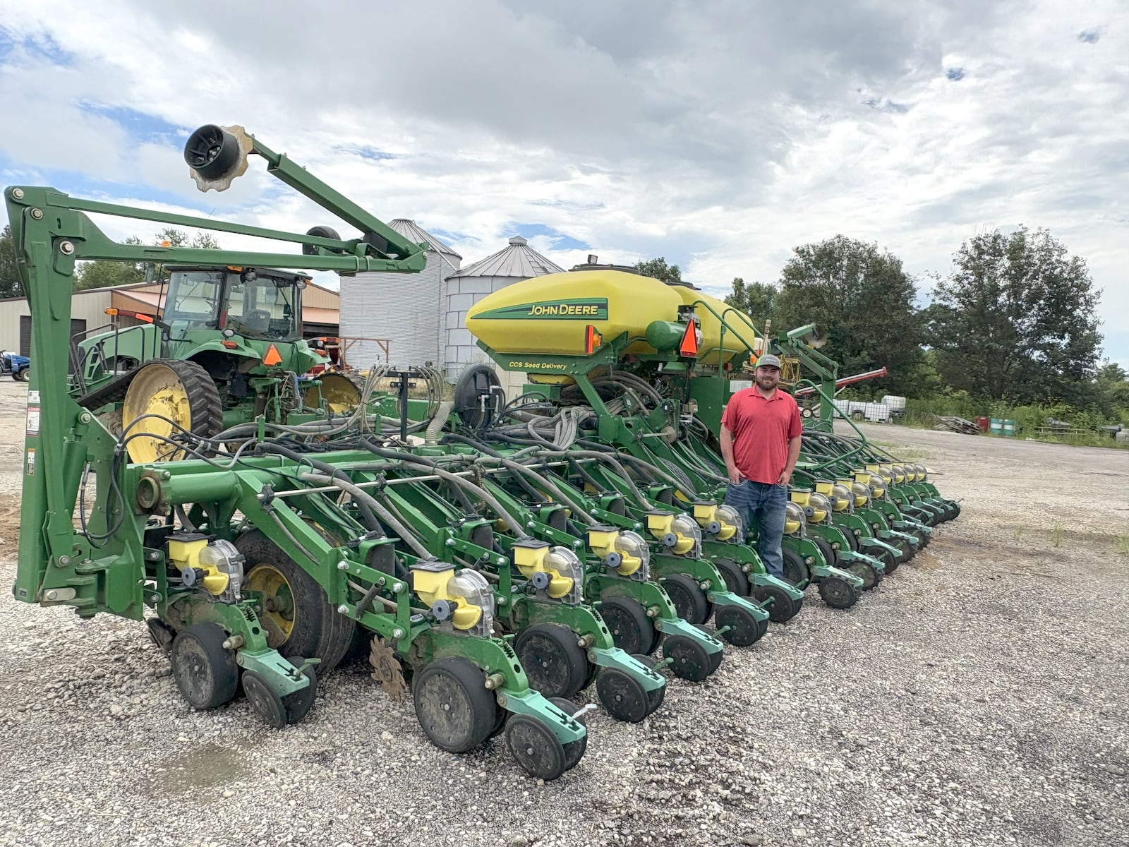 Grant Lucas stands alongside the massive 16-row corn planter he used to plant the bountiful field of corn on Nutt Road and the many other fields the family has among the 1,800 acres it now farms. TOM ARCHDEACON / CONTRIBUTED PHOTO