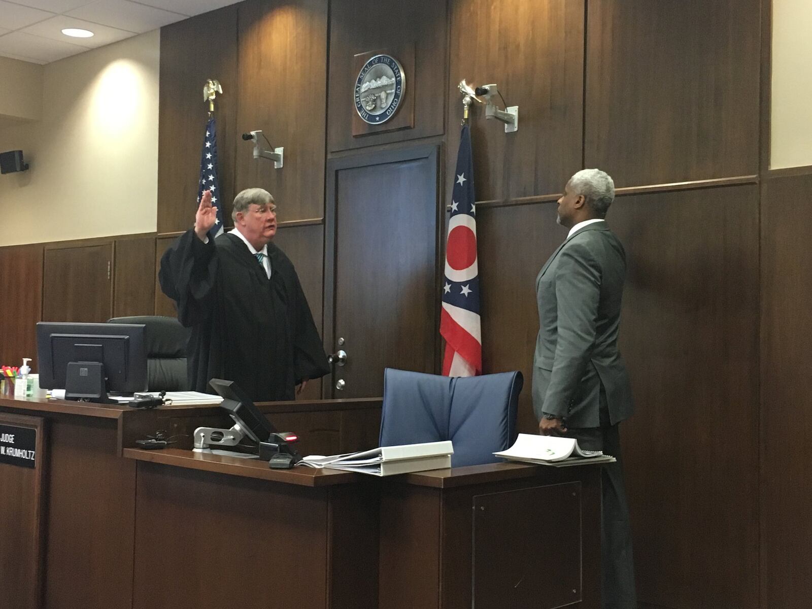 Dunbar High School varsity basketball coach Chuck Taylor is sworn in by Judge Michael Krumholtz in Montgomery County Common Pleas Court. Dayton Public Schools sued the OHSAA for its decision to remove Dunbar from the boys basketball tournament after the state alleged an ineligible player participated in a win over Thurgood Marshall. JEREMY KELLEY/STAFF
