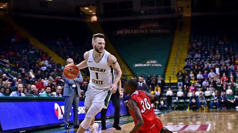 Wright State s Bill Wampler drives around Miami s Aboulaye Harouna during Wednesday night s gamea at the Nutter Center. Joseph Craven/CONTRIBUTED