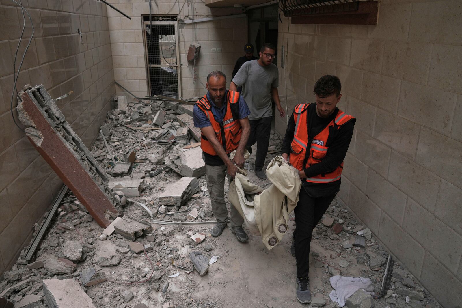 Palestinians civil defense workers carry the remains of a person killed during an Israeli airstrike on a residential building in Gaza City, Thursday, April 24, 2025. (AP Photo/Jehad Alshrafi)