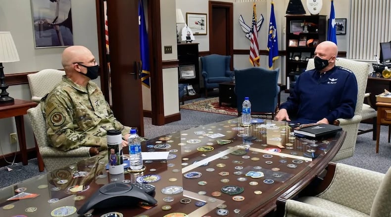 Gen. Arnold W. Bunch Jr., then-commander of the Air Force Materiel Command, talks with Gen. John W. "Jay" Raymond, chief of space operations, U.S. Space Force, inside AFMC headquarters at Wright-Patterson Air Force Base,  in March 2021. (U.S. Air Force photo by Ty Greenlees)