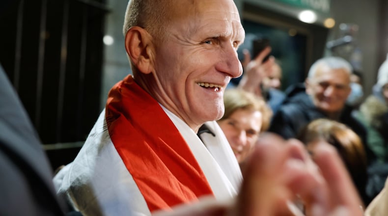 Nobel Peace Prize laureate Ales Bialiatski, one of released Belarusian prisoners, smiles surrounded by his supporters as he arrives at the U.S. Embassy in Vilnius, Lithuania, on Saturday, Dec. 13, 2025.(AP Photo/Mindaugas Kulbis)