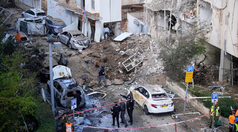 Israeli security and rescue forces respond at the site of an Iranian missile strike in Tel Aviv, Israel, Tuesday, March 24, 2026. (AP Photo/Ohad Zwigenberg)