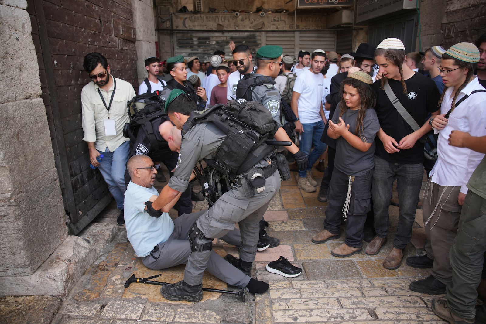 Israeli police officers assist a Palestinian man after he was pushed by right wing Israelis as they mark Jerusalem Day, an Israeli holiday celebrating the capture of east Jerusalem in the 1967 Mideast war, in Jerusalem's Old City, Monday, May 26, 2025. (AP Photo/Ohad Zwigenberg)