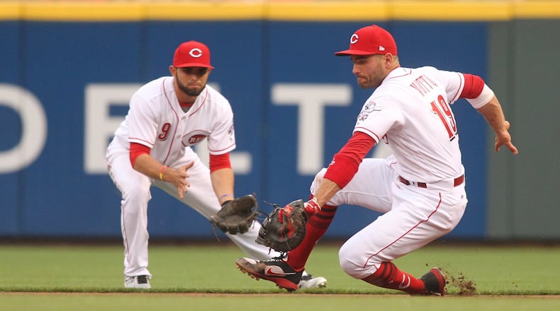 Reds first baseman Joey Votto fields a ball in front of second baseman Jose Peraza against the Brewers on Friday, April 14, 2017, at Great American Ball Park in Cincinnati. David Jablonski/Staff